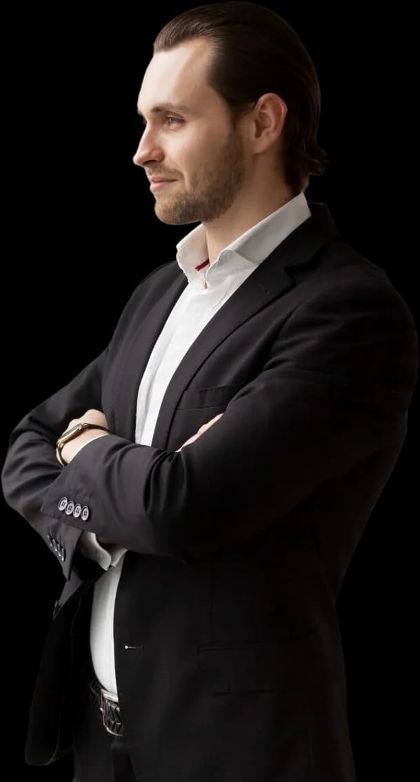 A leader in a black suit, arms crossed, looking ahead